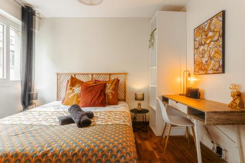 a bedroom with a bed with a desk and a stuffed animal on it at Jungle Saintaise - Appartement, Hypercentre, Fibre, Tv 4K, Parking Privé Payant in Saintes