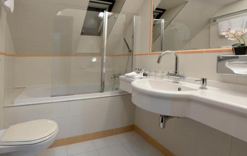 a bathroom with a toilet and a sink and a shower at Hotel Grand in Český Krumlov