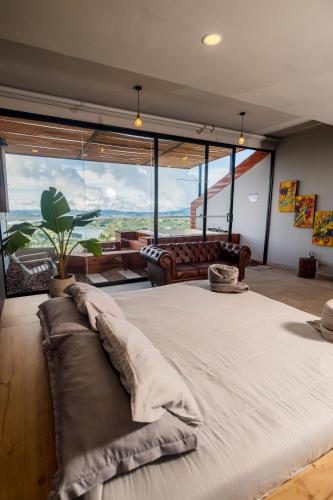 a large bed in a room with a large window at Montecielo Hosting in Guatapé