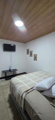 a bedroom with a bed and a tv on the wall at Casa Petunia, Managua in Managua