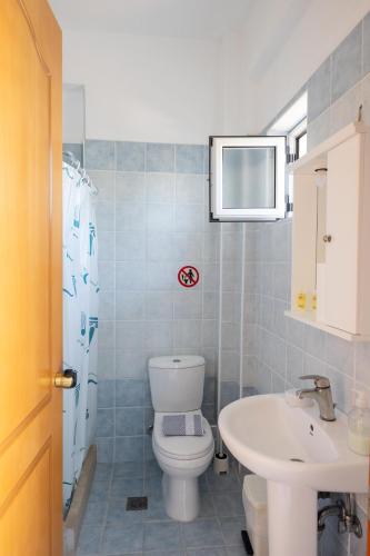 a bathroom with a toilet and a sink at Kipriotis Hotel in Arkoudi