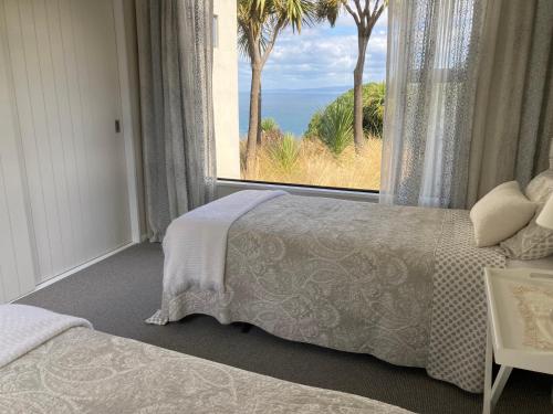 a bedroom with two beds and a large window at Oceanview Haven B&B in Dunedin
