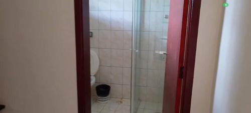 a bathroom with a toilet and a glass shower at Spin world Clube São Roque in São Roque