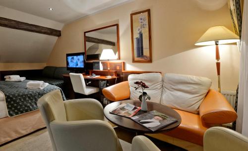 a hotel room with a couch and a table at Hotel Grand in Český Krumlov