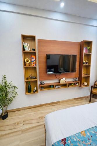 a bedroom with a tv on a wall at Sunhaven Studio I Work & Leisure Stays I Near Expo Mart in Greater Noida