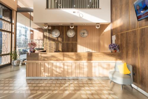 a lobby with a counter and clocks on the wall at Liyu Hotel Apartment in Addis Ababa