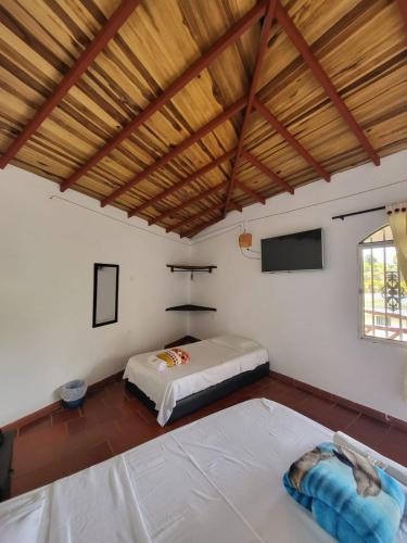 a bedroom with two beds in a room at Hotel Hacienda Rincon del Cielo in Curití