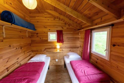 a room with two beds in a log cabin at Camping l'Estela sur le GR70 in Le Monastier sur Gazeille