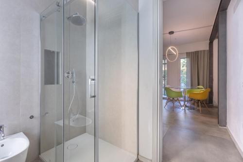 a bathroom with a glass shower and a table at Suite Home Ferrara in Ferrara
