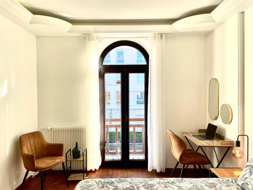 a bedroom with a bed and a desk and chairs at Maison Villa Foch in Meaux
