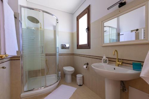 un bagno con doccia, lavandino e WC di Villa Elysia a Porto Rafti