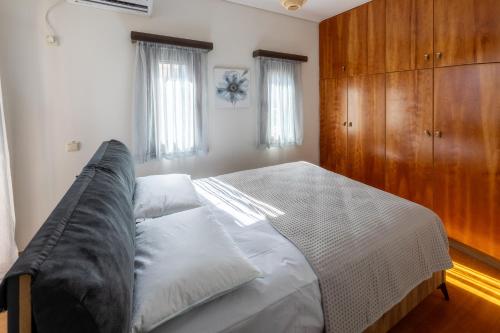 una camera da letto con un letto e un armadio in legno di Villa Elysia a Porto Rafti