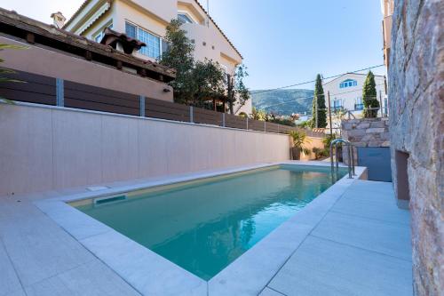 una piscina davanti a una casa di Villa Elysia a Porto Rafti