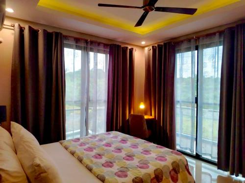 a bedroom with a bed and a large window at Staycation at Sandari Batulao Overlooking Spot in Calo