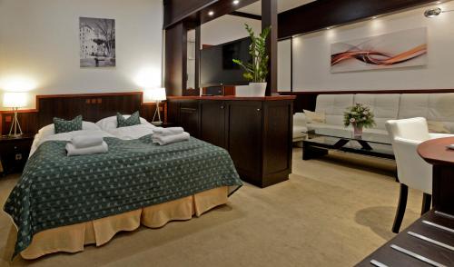 a bedroom with a large bed and a living room at Hotel Grand in Český Krumlov