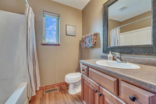 a bathroom with a sink and a toilet and a mirror at Bridges Bay Vacation Cabin 69 in Arnolds Park