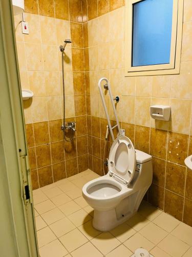 a bathroom with a toilet with the lid up at العييري للشقق المخدومة in Dammam