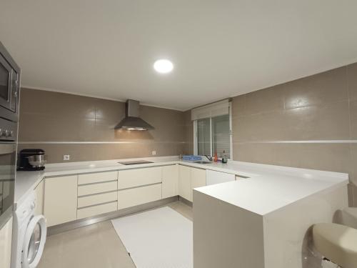 a kitchen with white cabinets and a white counter top at La Llar del Magraner in Barraca de Aguas Vivas