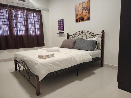 a bedroom with a large bed with white sheets at EcoHill Serenity Suites in Semenyih
