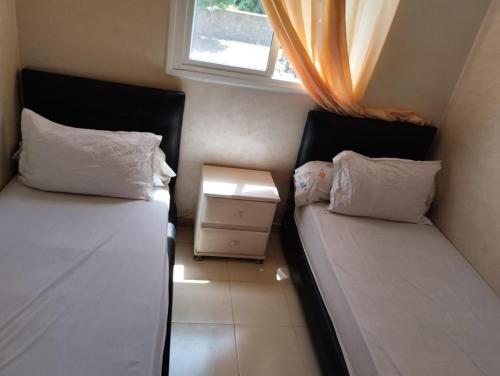 a small room with two beds and a window at jardaine d'Ifrane in Ifrane