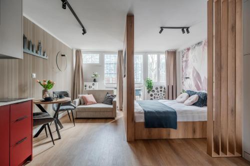 a bedroom with a bed and a living room at Pereca City Centre Studios by Arrenda in Warsaw