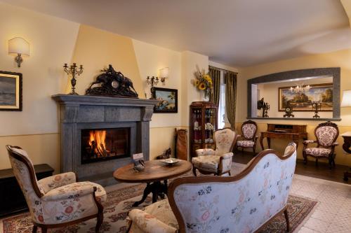 a living room with a fireplace and chairs at Hotel San Gregorio in Pienza