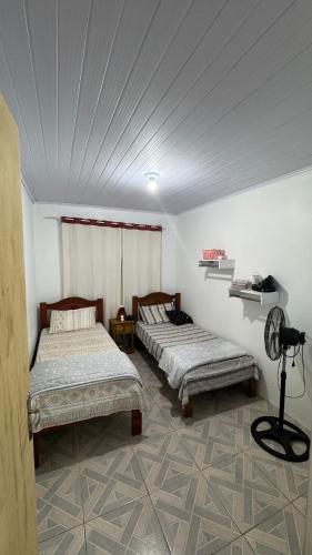 two beds in a room with a ceiling at House on Hermenegildo Beach in Santa Vitória do Palmar