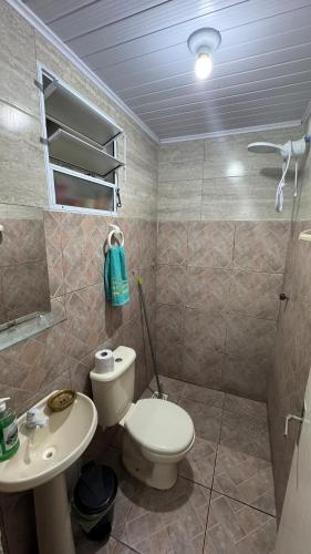 a bathroom with a toilet and a sink at House on Hermenegildo Beach in Santa Vitória do Palmar