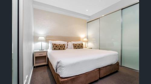 a bedroom with a large white bed with two pillows at Hi 5 star Adelaide City Luxury Oasis in Adelaide