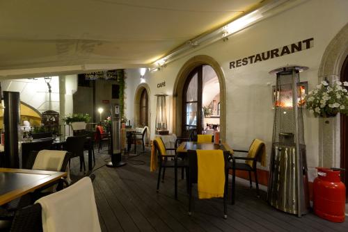 a restaurant with yellow chairs and tables in a room at Hotel Grand in Český Krumlov