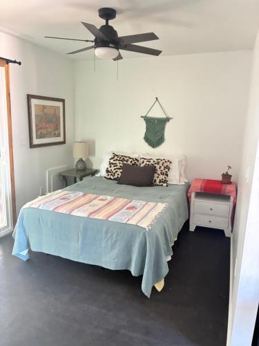 a bedroom with a bed and a ceiling fan at Painted sky casita in San Diego