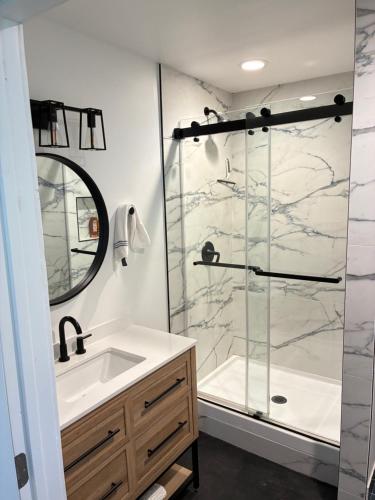 a bathroom with a sink and a glass shower at Painted sky casita in San Diego