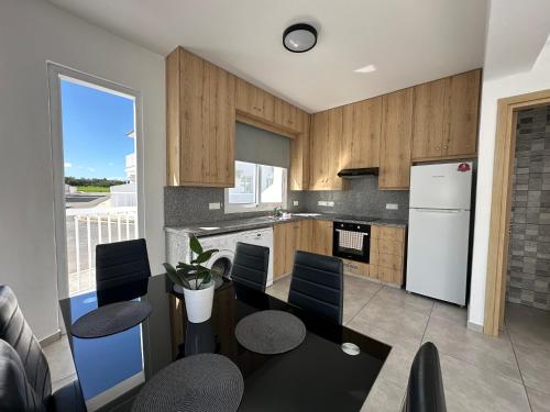 a kitchen with a table and chairs and a refrigerator at Ocean Breeze 2BR House in Paralimni