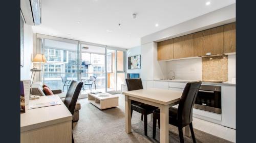 a kitchen and living room with a table and chairs at Hi 5 star Adelaide City Luxury Oasis in Adelaide