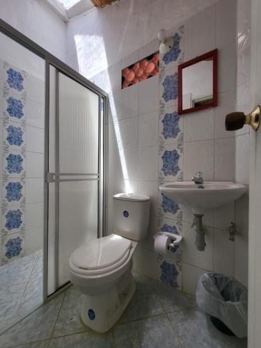a bathroom with a toilet and a sink at Hotel Hacienda Rincon del Cielo in Curití