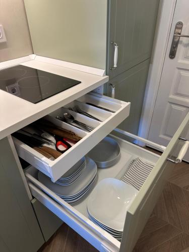 an open refrigerator with plates and utensils in it at Cozy Studio with Seaview in Costa Del Silencio