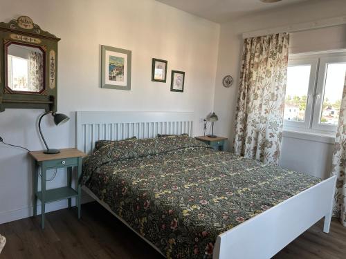 a bedroom with a bed and two tables and a window at Cozy Studio with Seaview in Costa Del Silencio