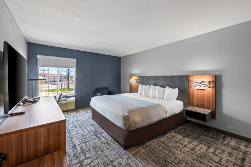 a hotel room with a large bed and a desk at Quality Inn & Suites Manhattan in Manhattan