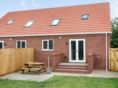 a brick house with a bench and a wooden fence at Dawson Park 9 - Uk12668 in Mablethorpe