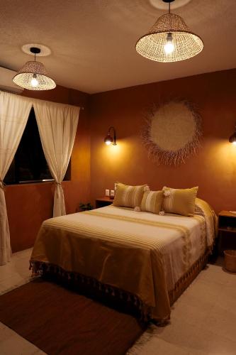 a bedroom with a large bed with two lights at Casa Pina in Oaxaca City