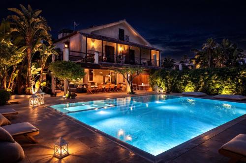 a swimming pool in front of a house at night at Villa Elisa - Luxury and Style by the Sea in Fontane Bianche