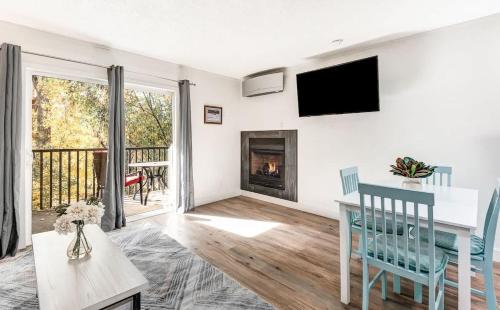 a living room with a table and a fireplace at Modern Style Third Floor Condo with Private Balcony in Bend