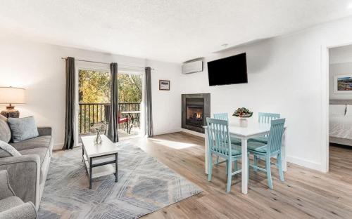 a living room with a table and a couch at Modern Style Third Floor Condo with Private Balcony in Bend