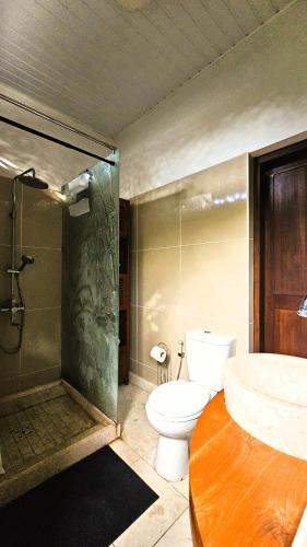 a bathroom with a toilet and a shower and a sink at TAHITI - PK18 Beach Cottage in Punaauia