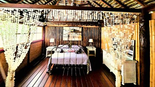 a bedroom with a bed and two tables with lamps at TAHITI - PK18 Beach Cottage in Punaauia
