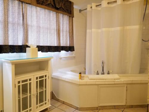 a bathroom with a tub and a sink and a shower at The Queen Anne Bed & Breakfast in Natchitoches