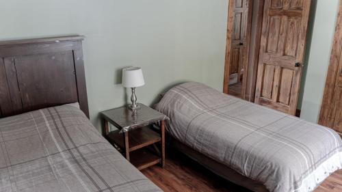 a bedroom with two beds and a table with a lamp at Grizzly Den in Valemount