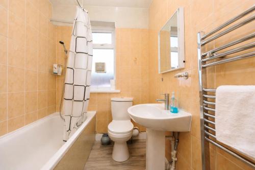 a bathroom with a toilet and a sink and a tub at The Range Nestled Nook in Manchester
