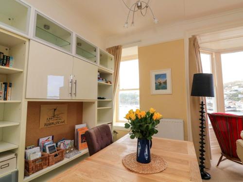 a dining room table with a vase of flowers on it at 3 Dartview in Dartmouth