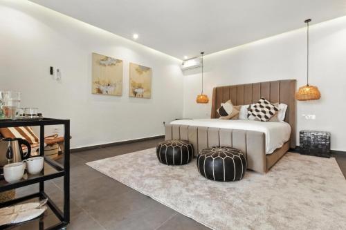 a bedroom with a bed with two ottomans at Dariana guesthouse in Marrakesh
